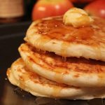 stack of vegan fluffy flax pancakes with apple syrup and vegan butter
