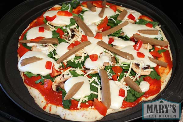 vegan pizza with vegan mozzarella cheese and vegan sausage