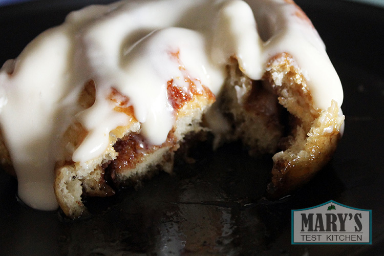 cut open cinnamon roll with frosting