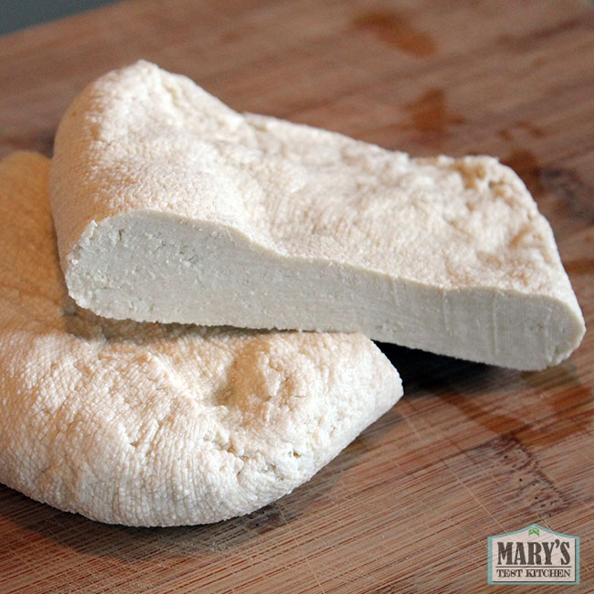 cut section of rustic homemade tofu made from soybeans and lemon