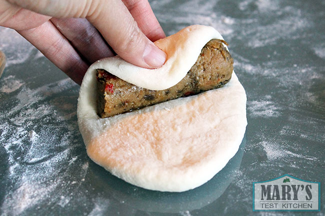 rolling up a vegan sausage in bread dough