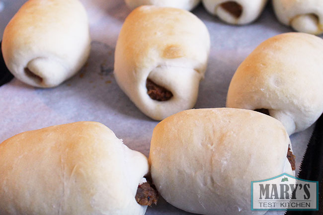 a tray of baked vegan sausage buns