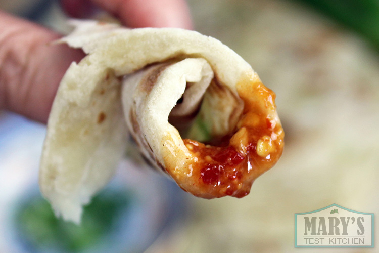 piece of green onion pancake with peanut sauce