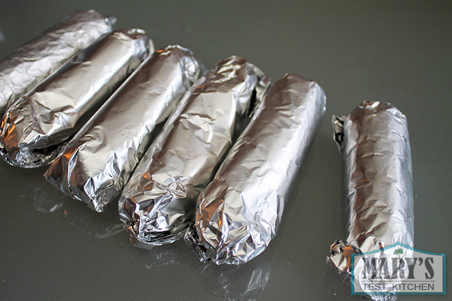 six raw vegan sausages in foil