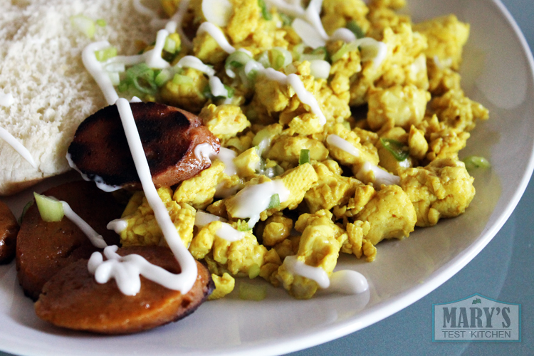 simple tofu scramble with white bun and crispy seitan sausage slices