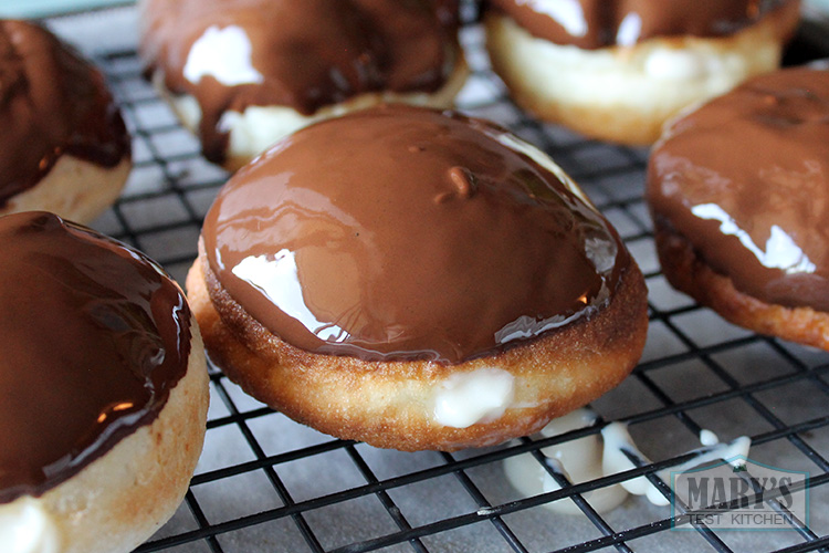 Freshly chocolate glazed shiny vegan boston cream doughnuts