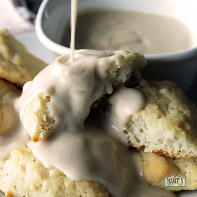 country gravy being poured over drop biscuits