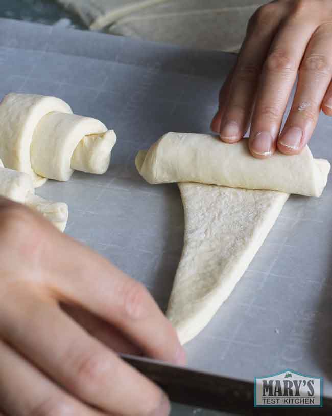 rolling up one crescent shaped croissant