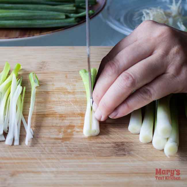 cutting white parts of green onions into threads