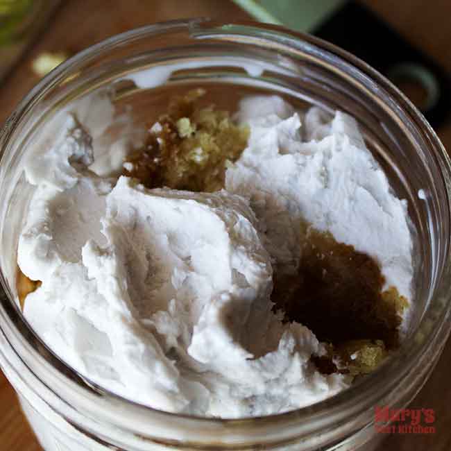 close up of whipped coconut cream on top of vanilla sponge