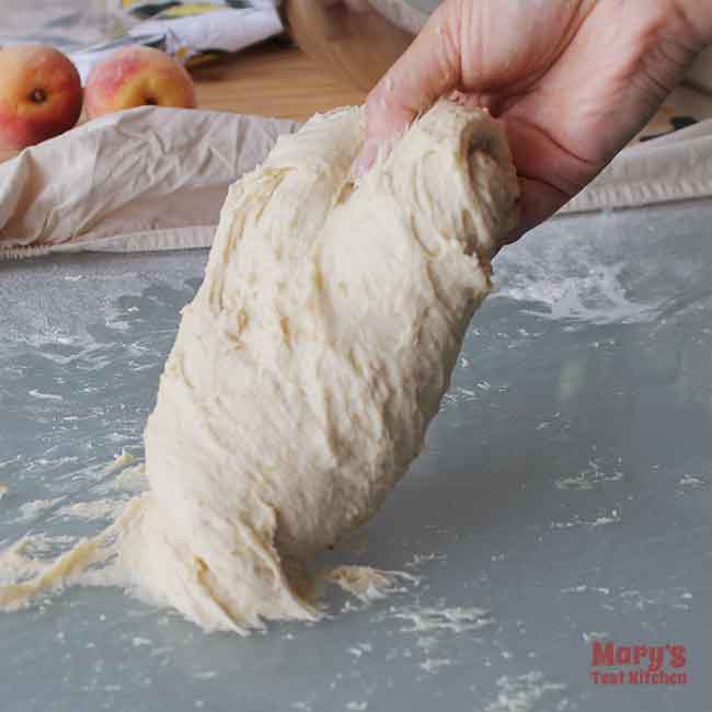 hand grabbing one size of a mound of dough