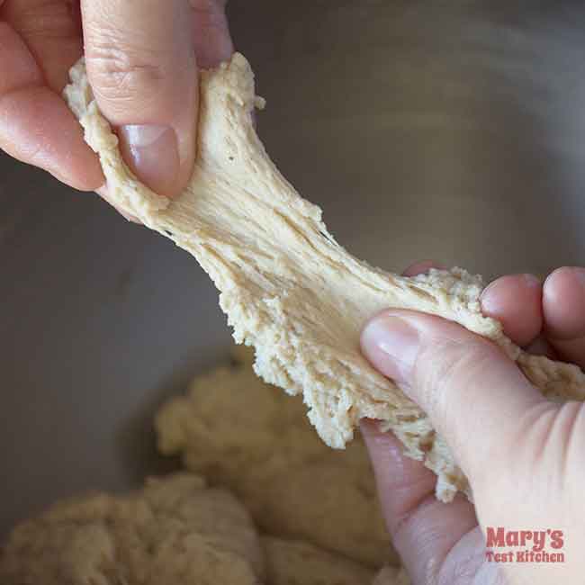 After second kneading, hands stretch small piece of dough about 2 inches