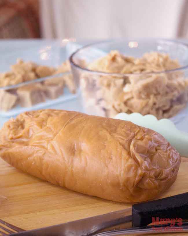 One pound log of chickeny chickless seitan in foreground, shred and cubed seitan in background