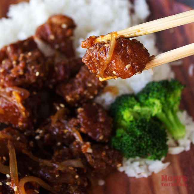 chopsticks holding a piece of Vegan Sesame Chicken