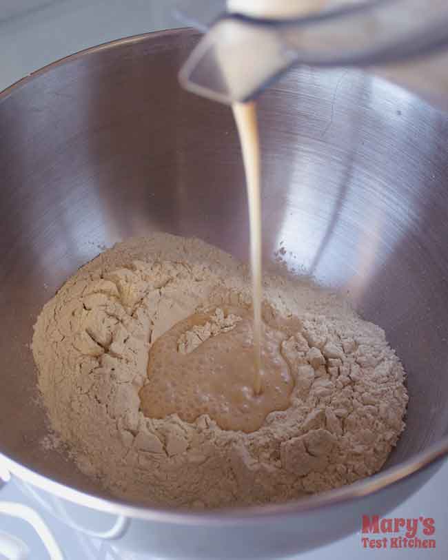 liquid ingredients being poured into bowl of gluten flour