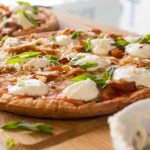 Easy Vegan Buffalo Chicken Pizza topped with vegan sour cream and green onions