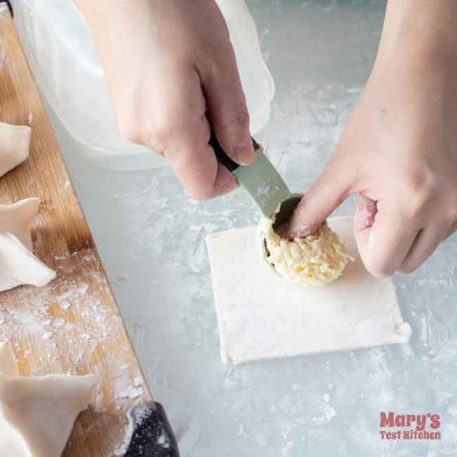 adding one tablespoon of vegan crab rangoon filling to wrapper