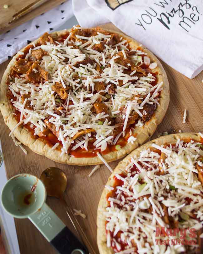 topped uncooked vegan buffalo chicken pizzas