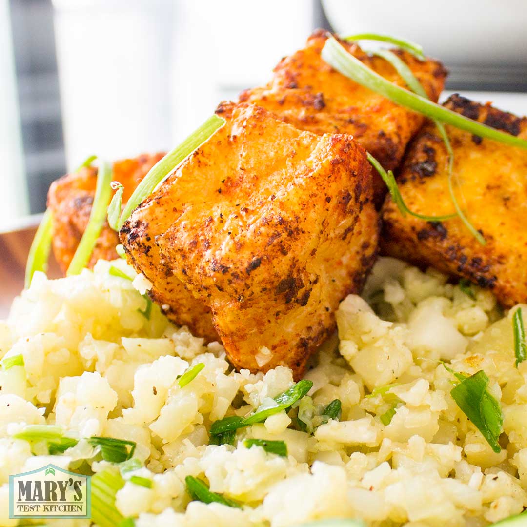 close up of crispy airfried spicy tofu puffs on cauliflower rice