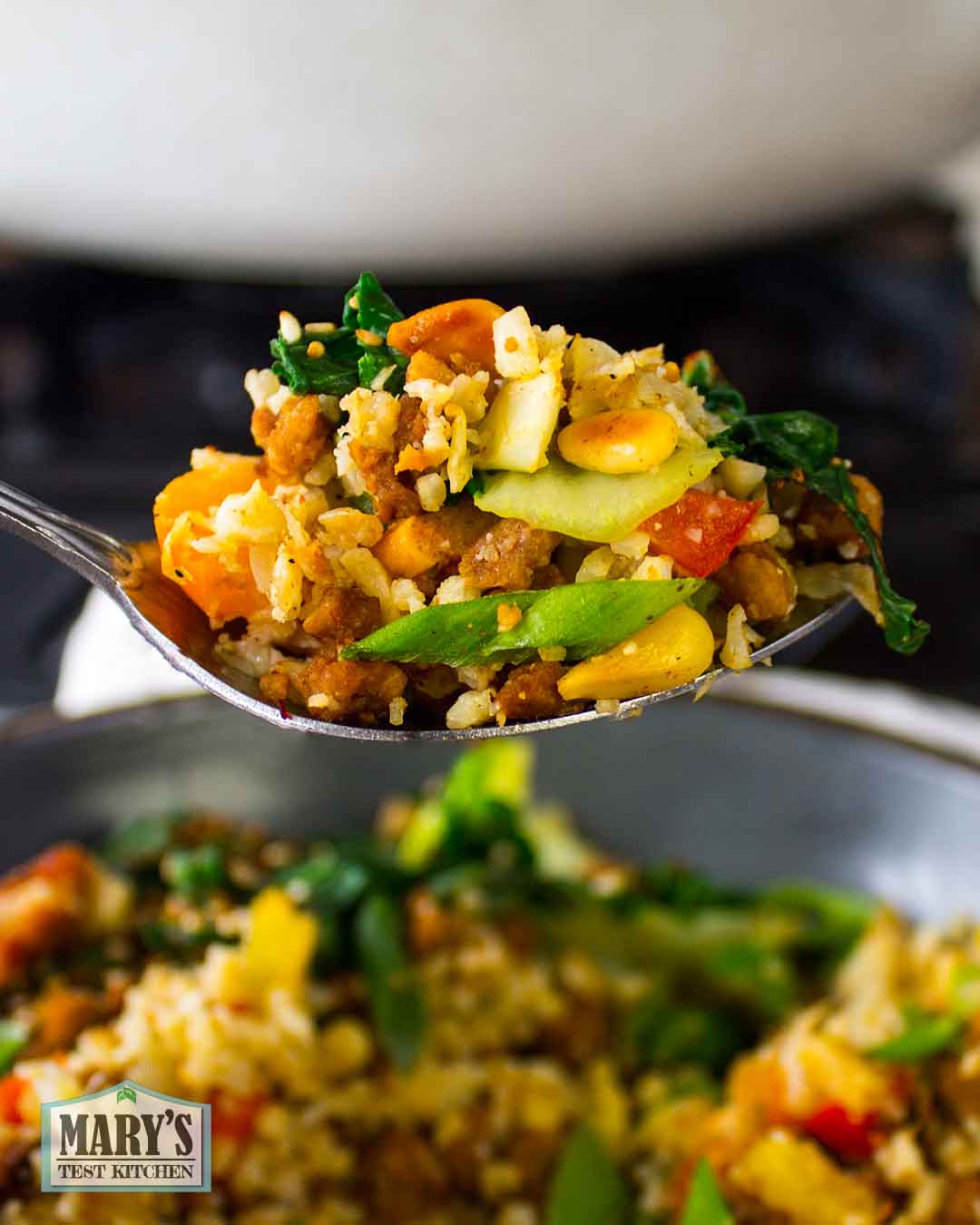 close up spoonful of Vegan Keto Fried Rice with pine nuts and chinese greens