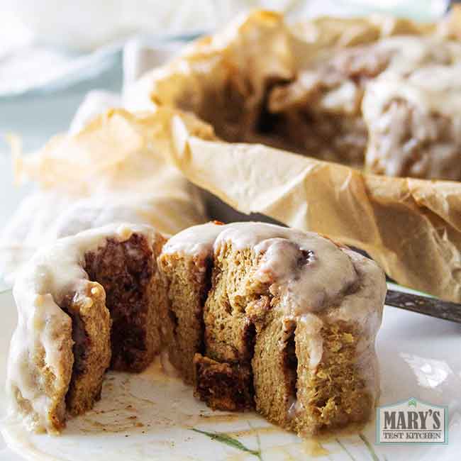 cream cheese frosted vegan keto cinnamon sticky bun cut in half