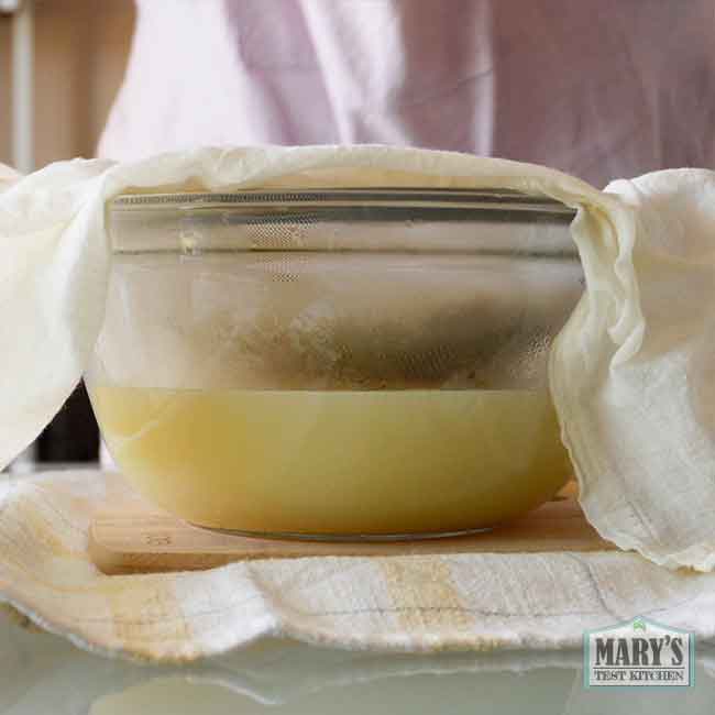 chickpea curds in cloth-lined sieve over a bowl