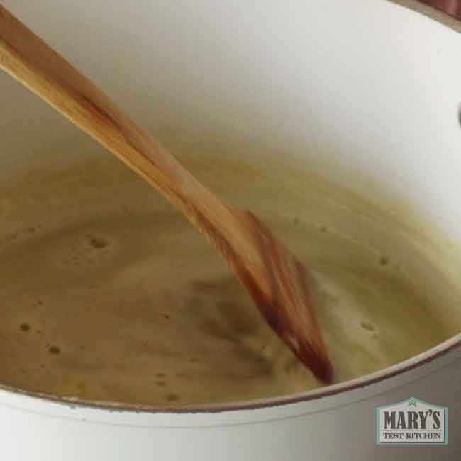 wooden spatula stirring green pea milk