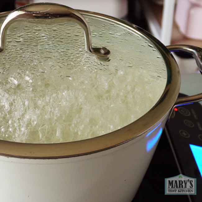 bubbling green pea milk with lid on pot