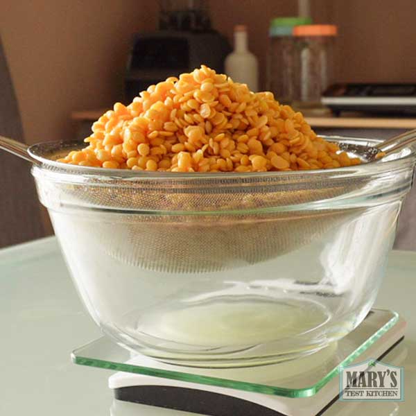 rehydrated pigeon peas in a sieve draining over a bowl