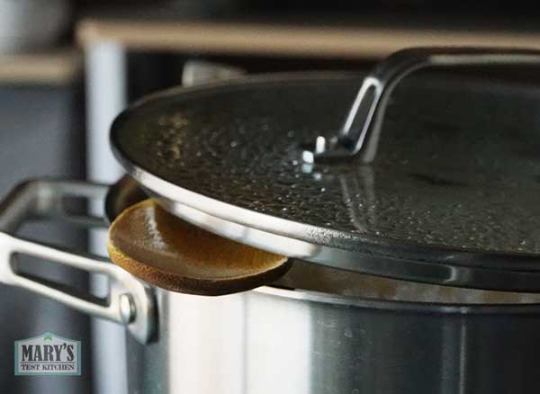 Tofu simmering in broth with lid propped open