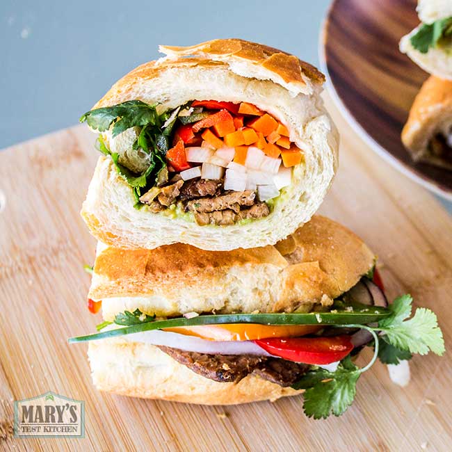 Vegan Banh Mi sandwich with pickled carrot and daikon, cilantro, jalapeno, onion, red peppers, tempeh and avocado pate.