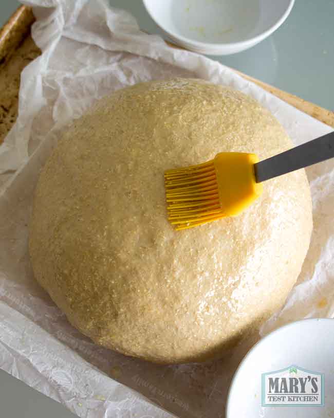 brushing risen loaf with water
