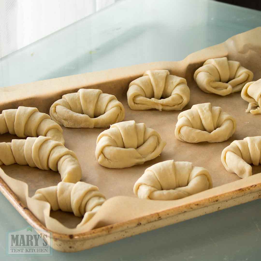 shaped easy vegan croissant dough on parchment-lined baking sheet