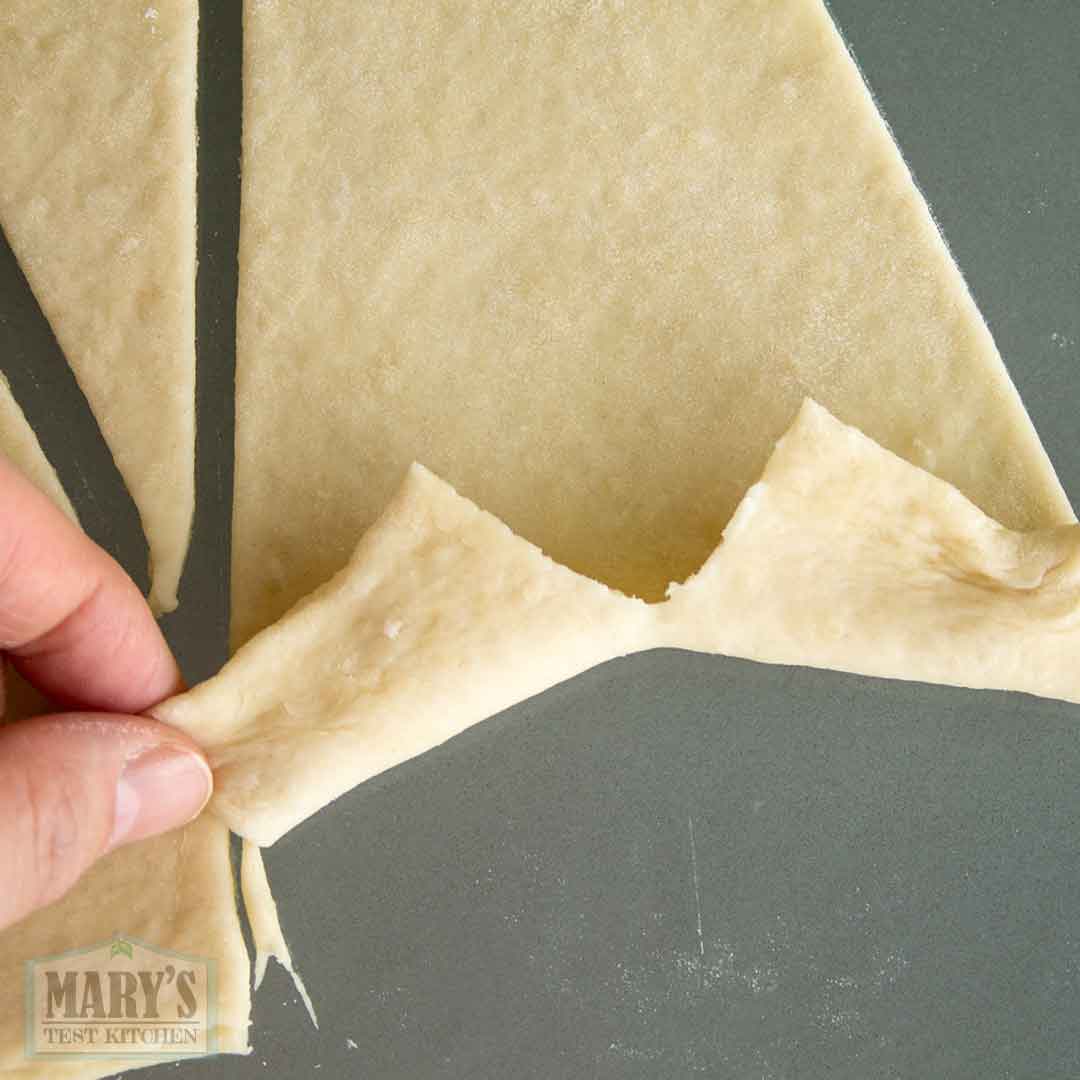 cut base in triangle of easy vegan croissant dough