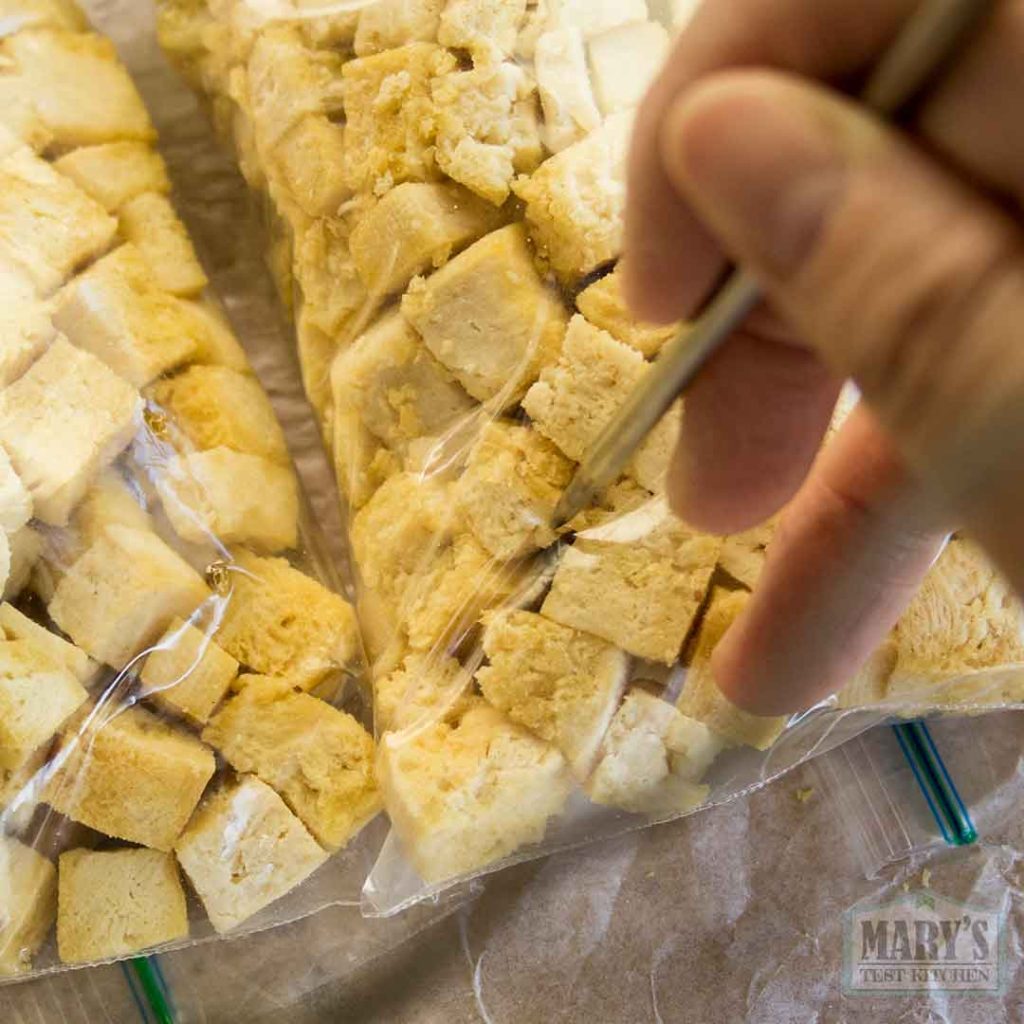 adding holes to the filled bags of inoculated tofu