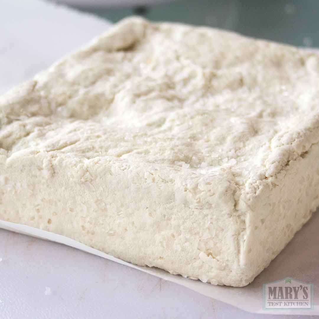 fresh white sesame cheese with 2% weight of salt pressed to the surface